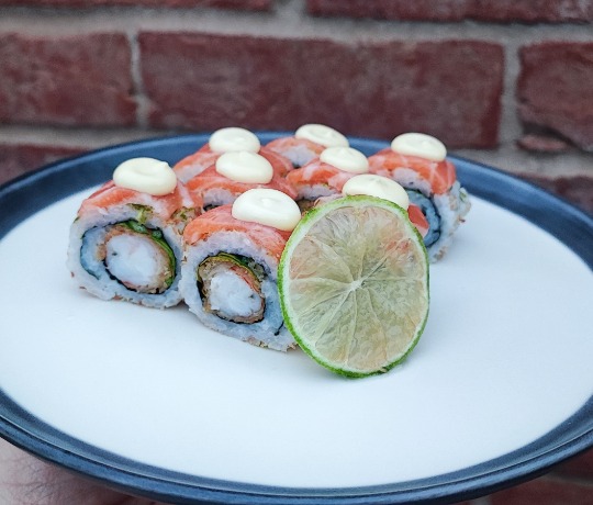 A plate with our weekly premium roll, the Shima Lime Roll, featuring coconut, lime, salmon, and prawn.